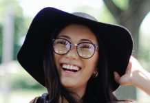 cheerful woman wearing floppy hat and glasses - photo by Leah Kelley on Pexels