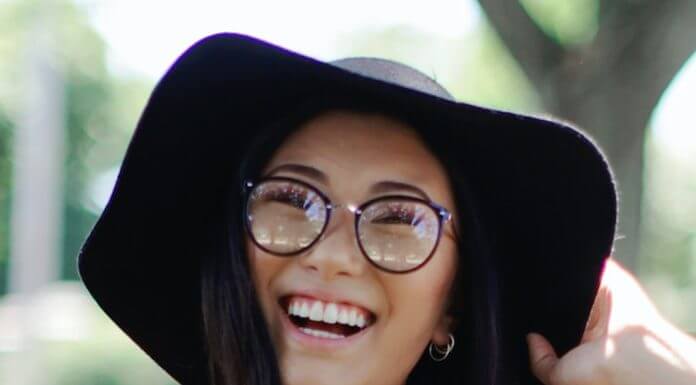 cheerful woman wearing floppy hat and glasses - photo by Leah Kelley on Pexels