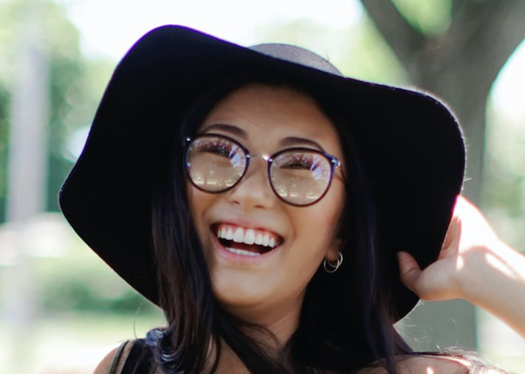 cheerful woman wearing floppy hat and glasses - photo by Leah Kelley on Pexels