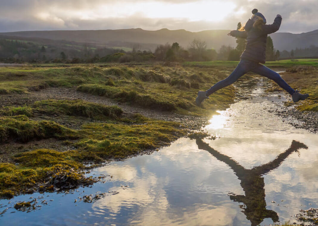 child jumping over water - yvonnestewarthenderson/Shutterstock.com