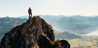 man on top of mountain after hike