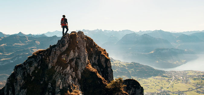 man on top of mountain after hike