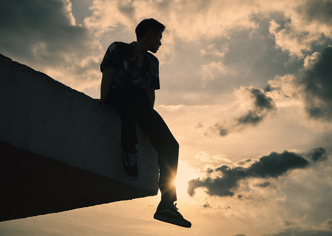 silhouette man sitting on edge of roof at sunset - photo by Khoa Võ on Pexels.com