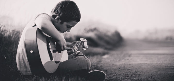 young man learning to play guitar