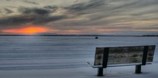 empty bench in winter at sunrise