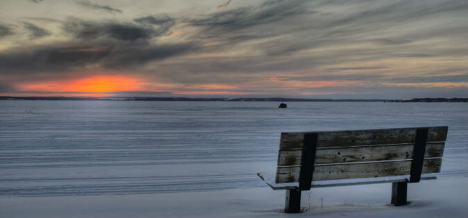 empty bench in winter at sunrise