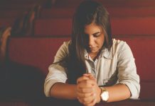 young woman praying in church - photo by Naassom Azevedo on Unsplash