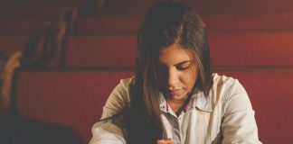 young woman praying in church - photo by Naassom Azevedo on Unsplash