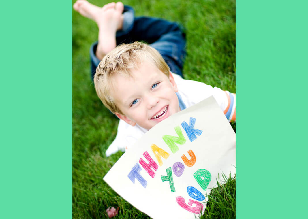 child holding sign that says, "Thank you, God" - madisonwi/iStock/Getty Images