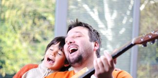 man playing guitar next to singing boy - ESB Professional/Shutterstock.com