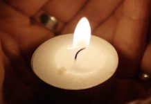 candle held in cupped hands