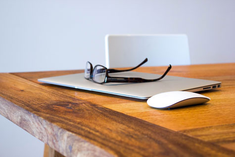 computer and glasses sitting on desk