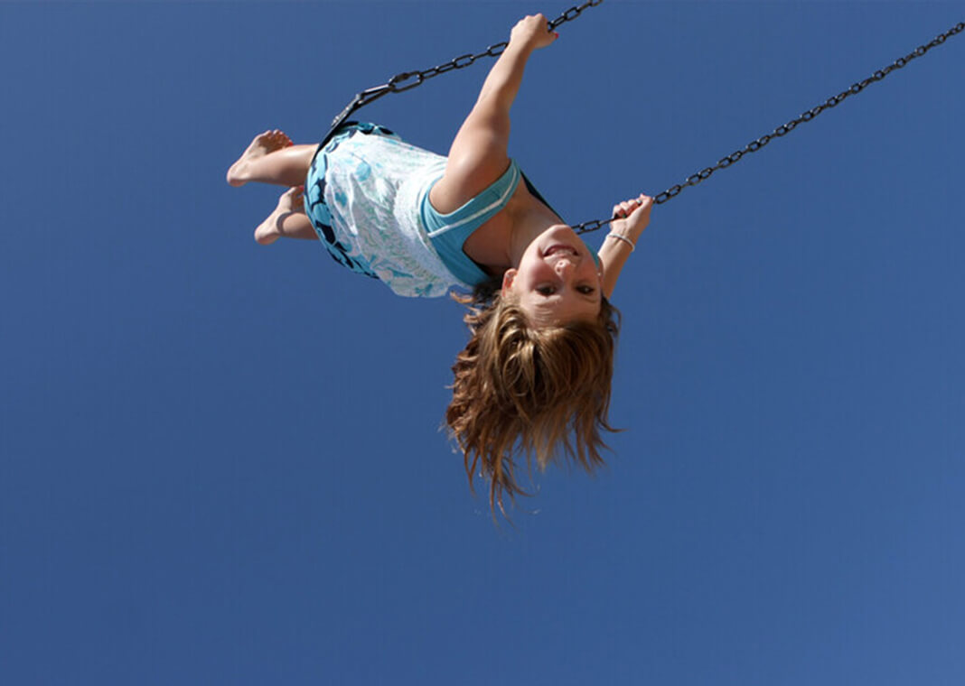 girl riding high on swing - LindaYolanda/iStock/Getty Images