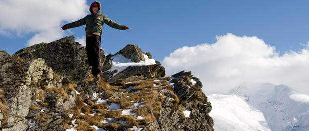 person standing on edge of mountain