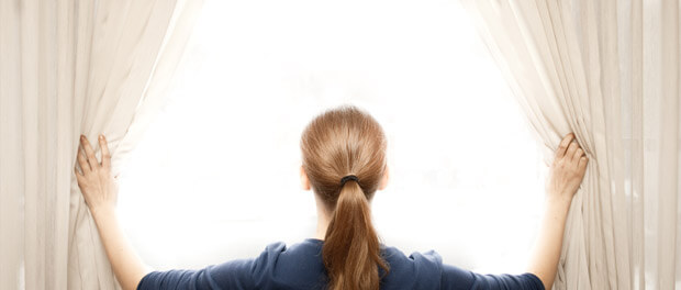 woman opening the window shades/curtains