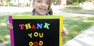 girl holding sign reading "Thank you, God"