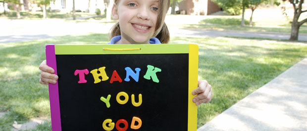 girl holding sign reading "Thank you, God"