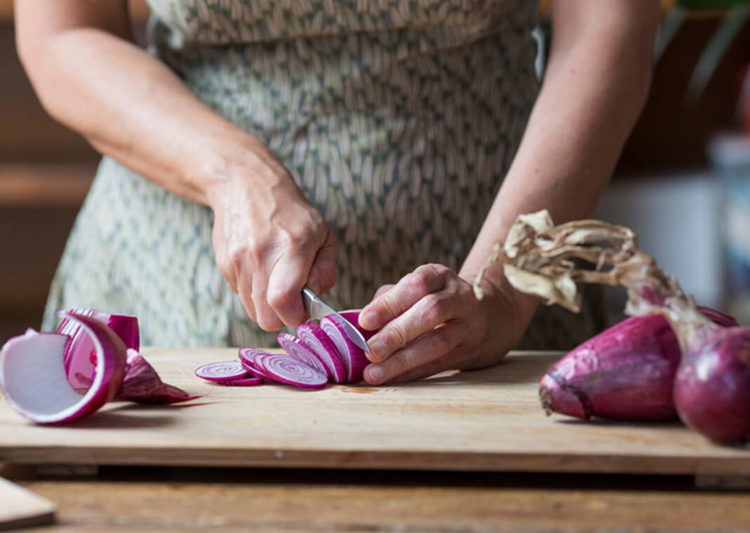 woman cutting onions - Westend61/Getty Images