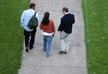 college students walking with professor