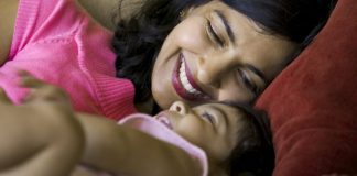 woman resting with child on couch