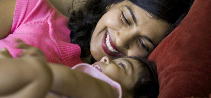 woman resting with child on couch