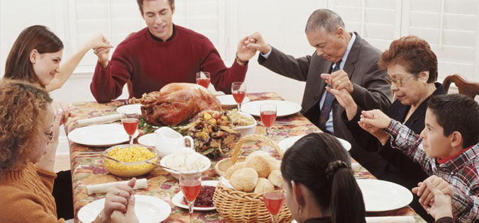 family praying around holiday table