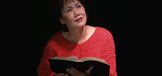 woman praying with Scripture