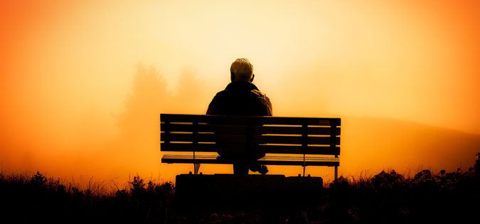 man on bench at winter sunset