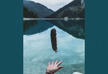 person letting go of feather - photo by Paul Gilmore on Unsplash