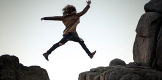 person shows courage by leaping over mountains