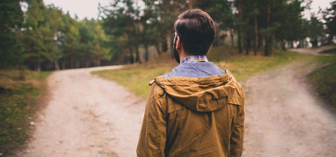 man standing at start of two paths