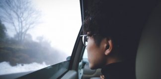 young man looking out car window