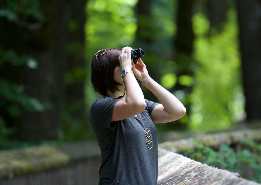 woman using binoculars - photo by Kayla Farmer on Unsplash