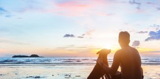 man and dog on beach in reflective scene