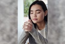 woman praying near window