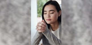 woman praying near window