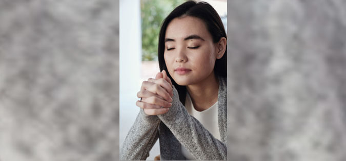 woman praying near window