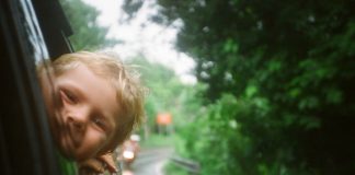 child with head out car window - photo by Anton Luzhkovsky on Unsplash