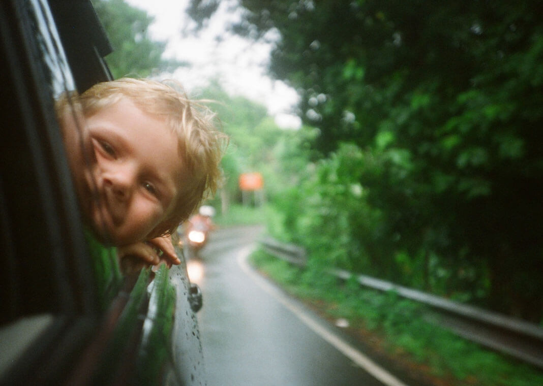 child with head out car window - photo by Anton Luzhkovsky on Unsplash