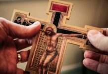 holding crucifix - photo by James Coleman on Unsplash