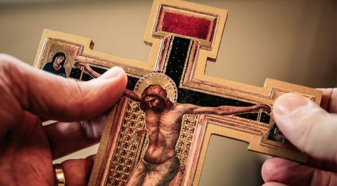 holding crucifix - photo by James Coleman on Unsplash