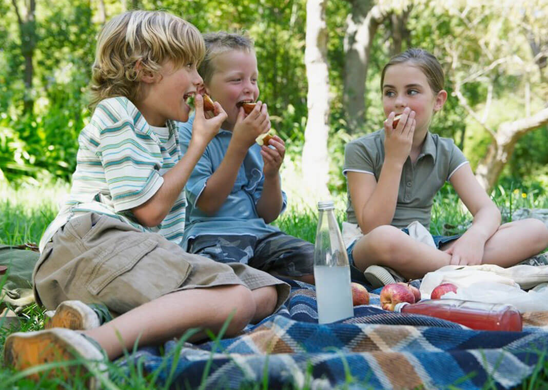 children eating outside as friends