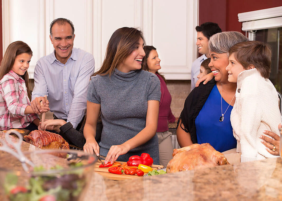 family in kitchen preparing Thanksgiving meal