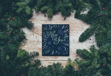 Happy New Year sign surrounded by evergreen branches - photo by Annie Spratt on Unsplash