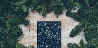 Happy New Year sign surrounded by evergreen branches - photo by Annie Spratt on Unsplash