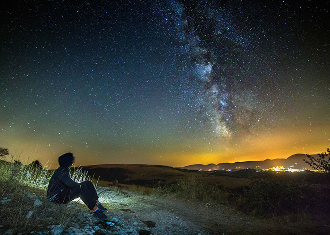 starry night with young man pondering in silence