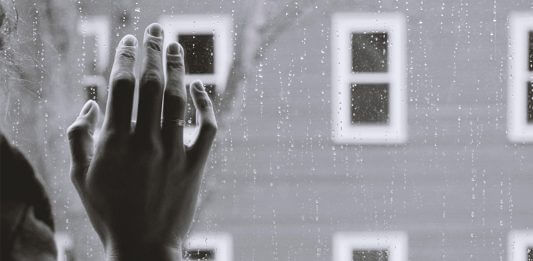 hand on rainy window - photo by Kristina Tripkovic on Unsplash