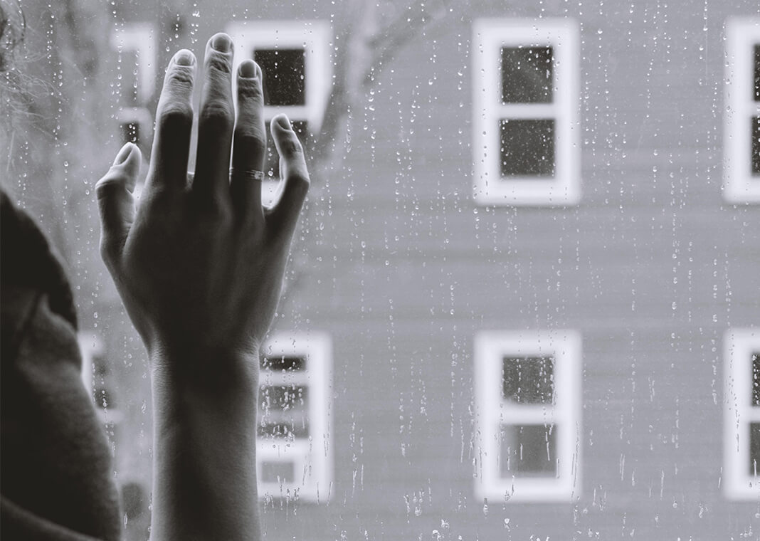 hand on rainy window - photo by Kristina Tripkovic on Unsplash