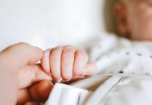 mother holding baby's hand - photo by Lisa from Pexels