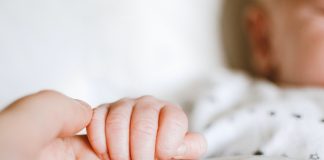 mother holding baby's hand - photo by Lisa from Pexels